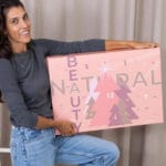Una mujer sujeta la caja del calendario de Adviento VeganBox 2024
