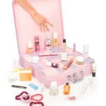 Una mano se dispone a coger uno de los productos del Calendario de Adviento Revolve 2024, con la caja abierta