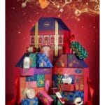 Tres cajas del Calendario de Adviento Sabon 2024 sobre un fondo rojo festivo