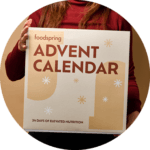 Una mujer sujeta la caja del calendario de adviento Foodspring 2024