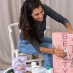 Una mujer abriendo una de las ventanas del Calendario de Adviento VeganBox 2024 "Natural Beauty"