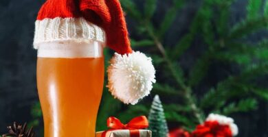 Un vaso de cerveza con un gorro de Papá Noel