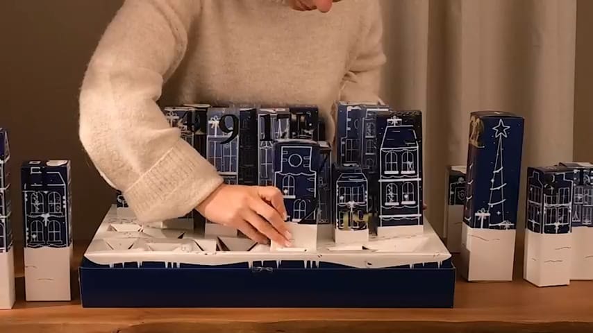 Una mujer monta la escena navideña del calendario 3D DIY de Jean & Len 2025