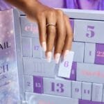 Una mujer coge una cajita numerada del Calendario de adviento Neonail 2026