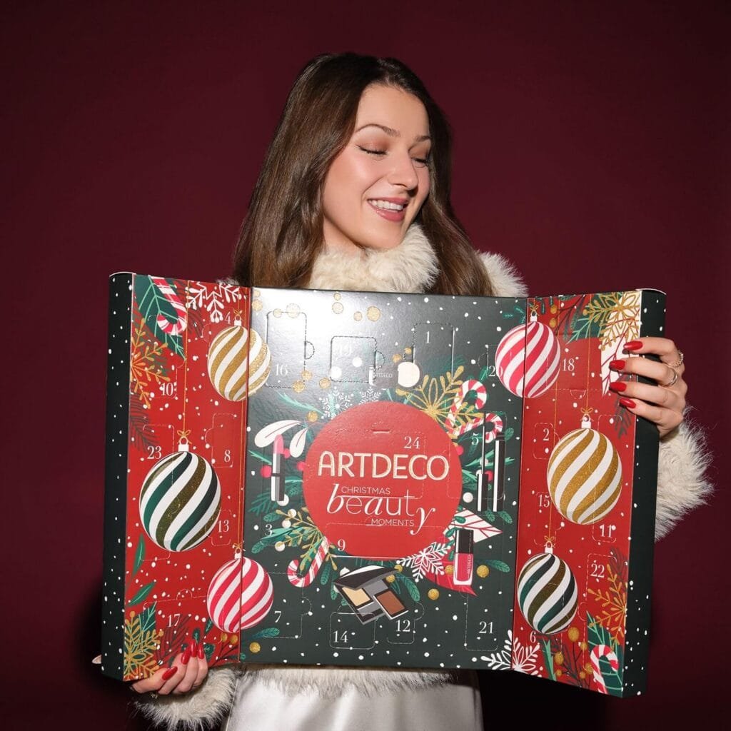 Una mujer sostiene la caja del Calendario de adviento Artdeco 2026