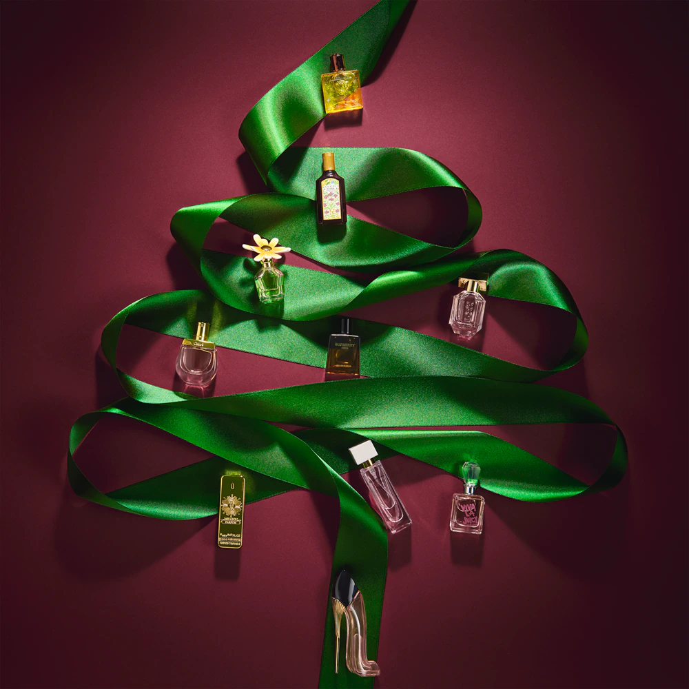 Los perfumes del Calendario de adviento Notino 12 Days of Fragrant Joys 2025 dibujando con una cinta verde un árbol de navidad Los perfumes del Calendario de adviento Notino 12 Days of Fragrant Joys 2025 dibujando con una cinta verde un árbol de navidad