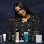 Una mujer posa con la caja y los productos del Calendario de Adviento Avant Skincare 2024