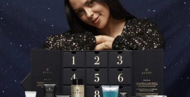 Una mujer posa con la caja y los productos del Calendario de Adviento Avant Skincare 2024