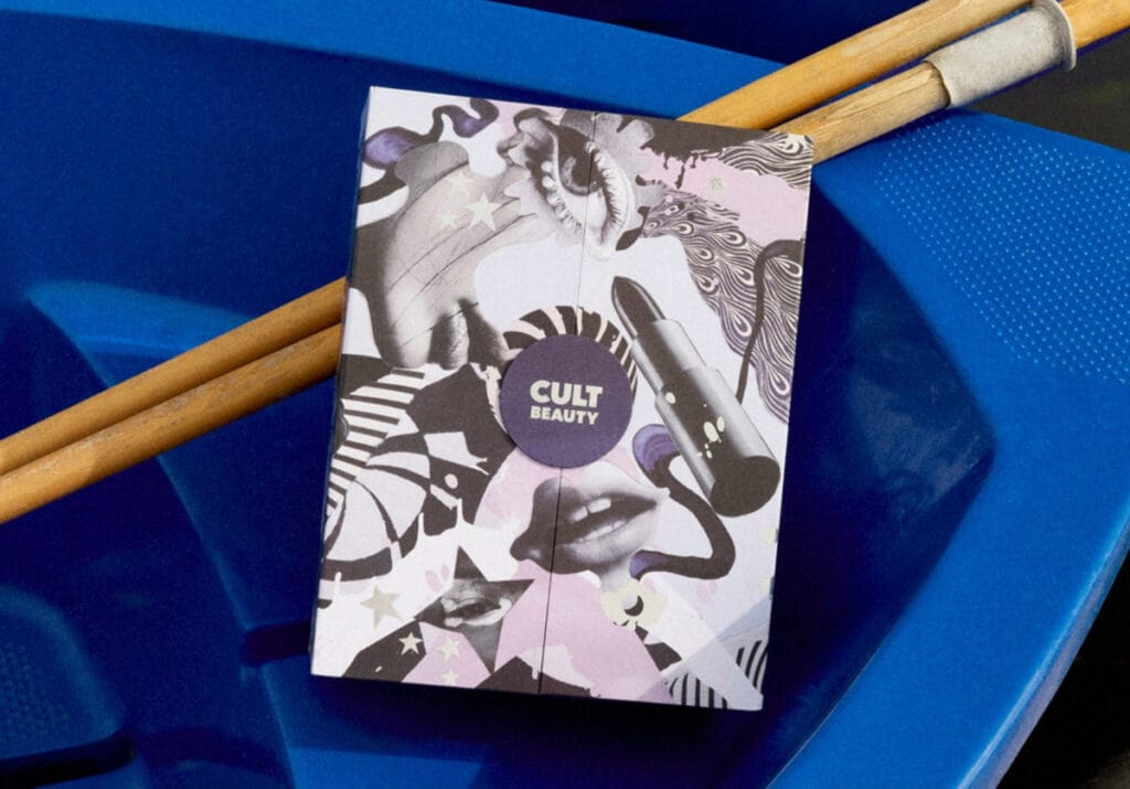 Calendario de Adviento Cult Beauty 2025: lista de espera abierta 1 La caja del Calendario de Adviento Cult Beauty 2025, en una barca azul con unos remos