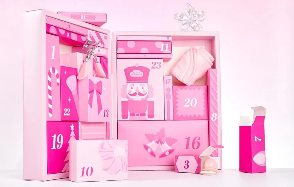 Calendario de Adviento Brushworks 2026 abierto, con 24 compartimentos y accesorios de belleza en tonos rosas.