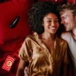 Una pareja promocionando el Calendario de adviento Lovehoney 2025 para parejas