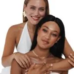 Dos modelos posan con joyas del calendario de Adviento Heideman 2024
