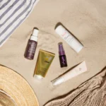 Productos del Calendario de Verano de Notino 2025 sobre la arena del mar