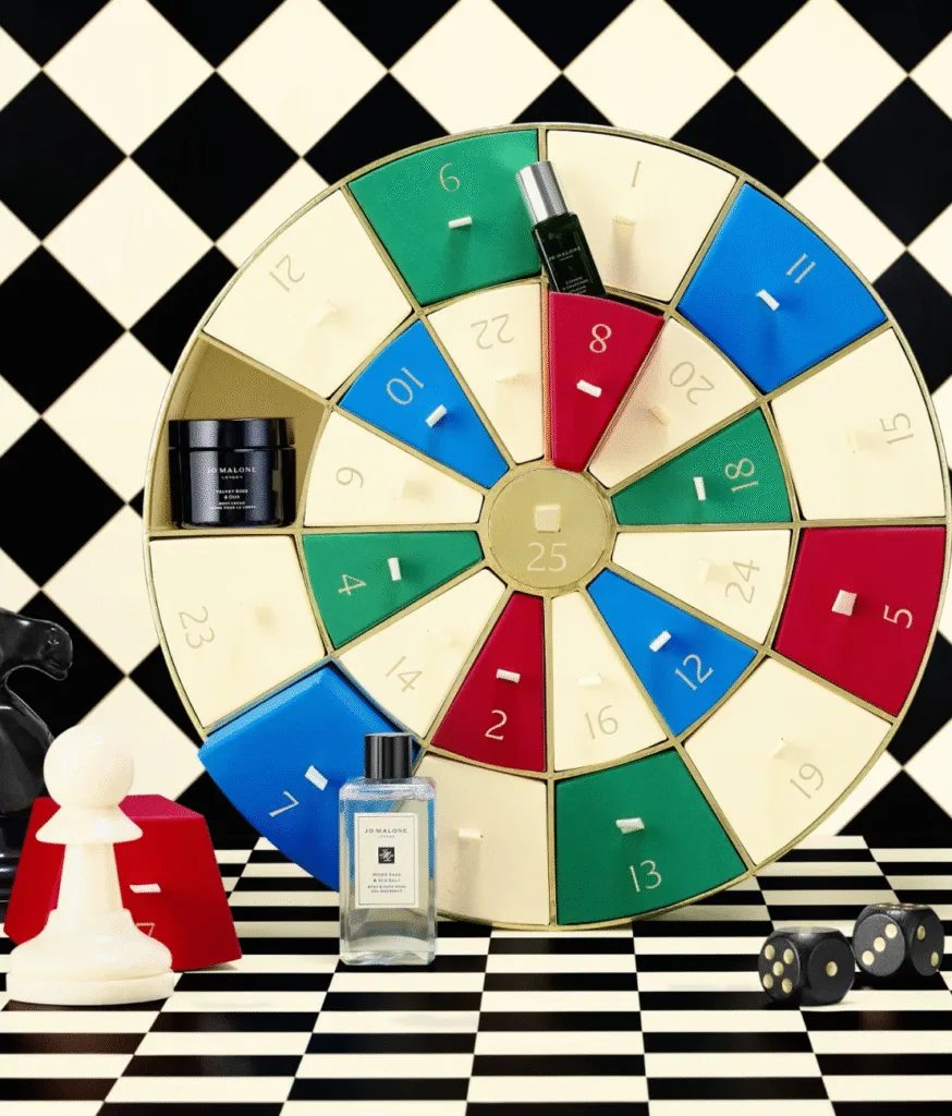 La caja y algunos de los productos del Calendario de adviento Jo Malone 2025 en un tablero de ajedrez