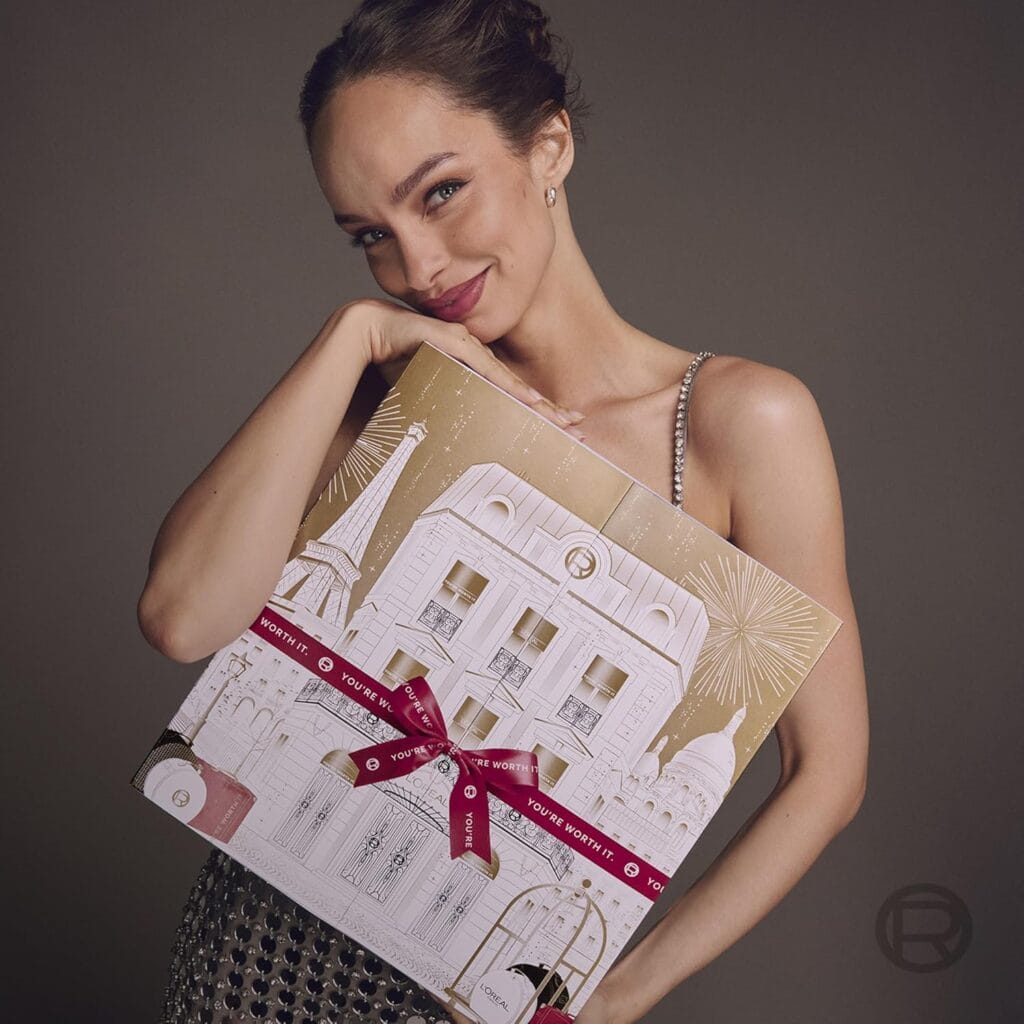 Una modelo posa con la caja del Calendario de adviento L'Oréal Paris 2025 de 24 días