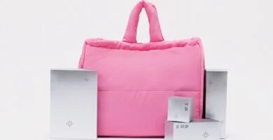 Calendario de adviento MiiN Cosmetics 2025 10 La bolsa neceser rosa junto a algunas cajas plateadas del Calendario de Adviento MiiN Cosmetics 2025