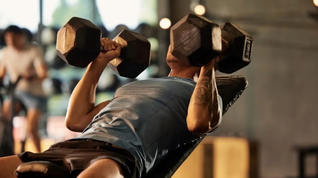Un hombre haciendo entrenamiento de fuerza con dos mancuernas