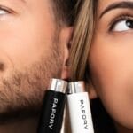 Un chico y una chica en primer plano junto a frasquitos con la marca Pafory