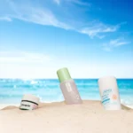 Productos del Calendario de Verano de Notino 2025 sobre la arena del mar