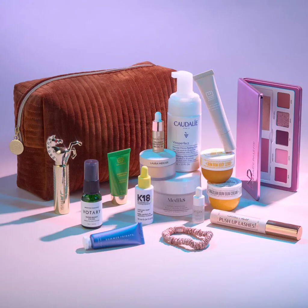 El bolso de terciopelo marrón y los productos incluidos en The Cult Bag of Tricks 2024 de Cult Beauty