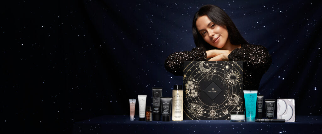 Una modelo posa con la caja y los productos del Calendario de Adviento Avant Skincare 2024